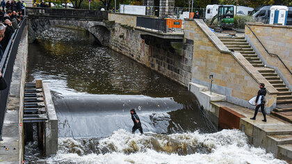 Surfer steht auf der Leinewelle in Hannover.