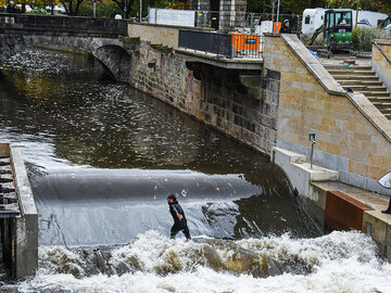 Surfer steht auf der Leinewelle in Hannover.