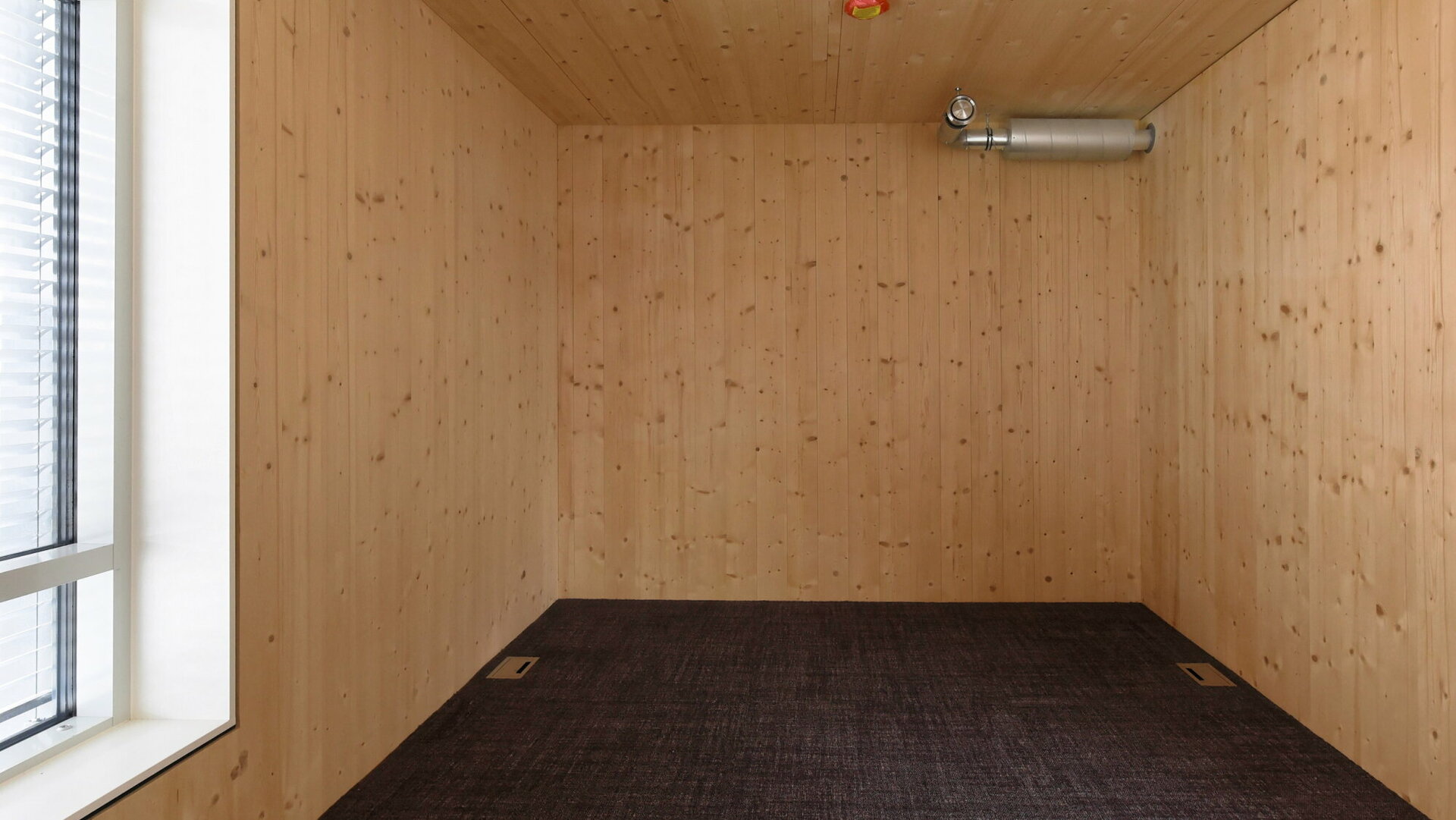 Die Holzwände im Schlafzimmer schaffen eine gemütliche Atmosphäre.